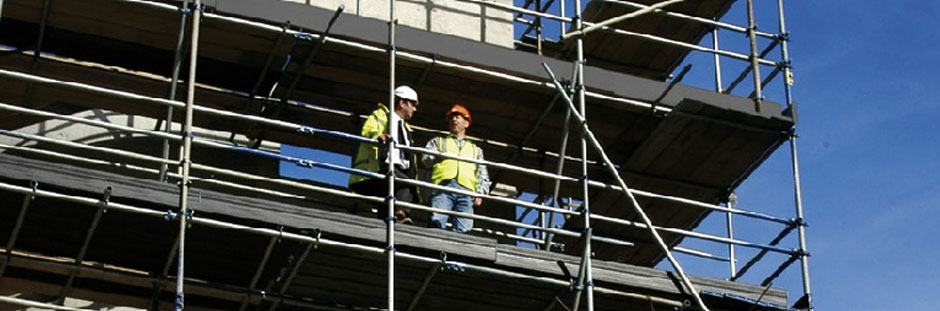 Photo of two workers standing on scaffolding that is made using Supadek plastic scaffolding boards.